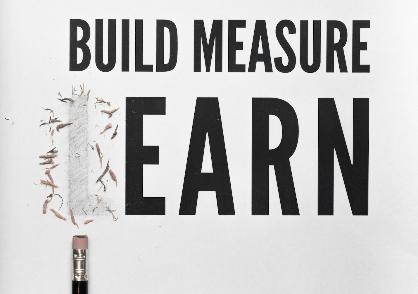 Build Measure Learn, with a black pencil erasing the L to make it Build Measure Earn
